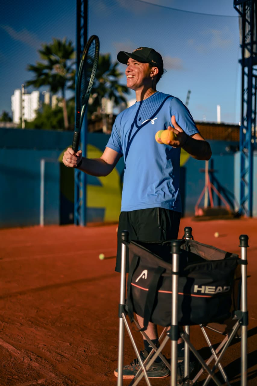 Professor sorrindo durante a aula na Fast Tennis Capim Macio